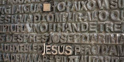 a gray concrete wall with biblical inscriptions